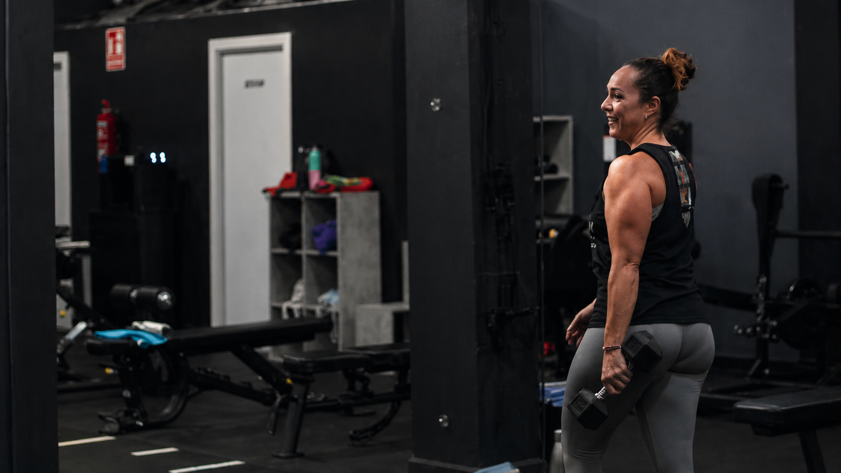 Sala de entrenamiento con pesas y una persona entrenando en Fast Training Center